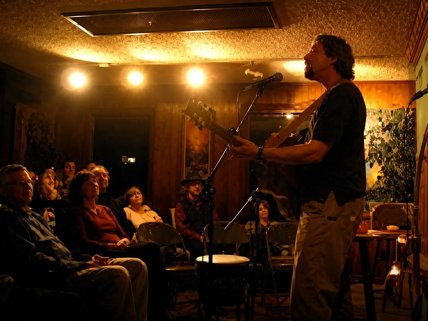 A performer singing at a microphone in a warmly lit intimate venue