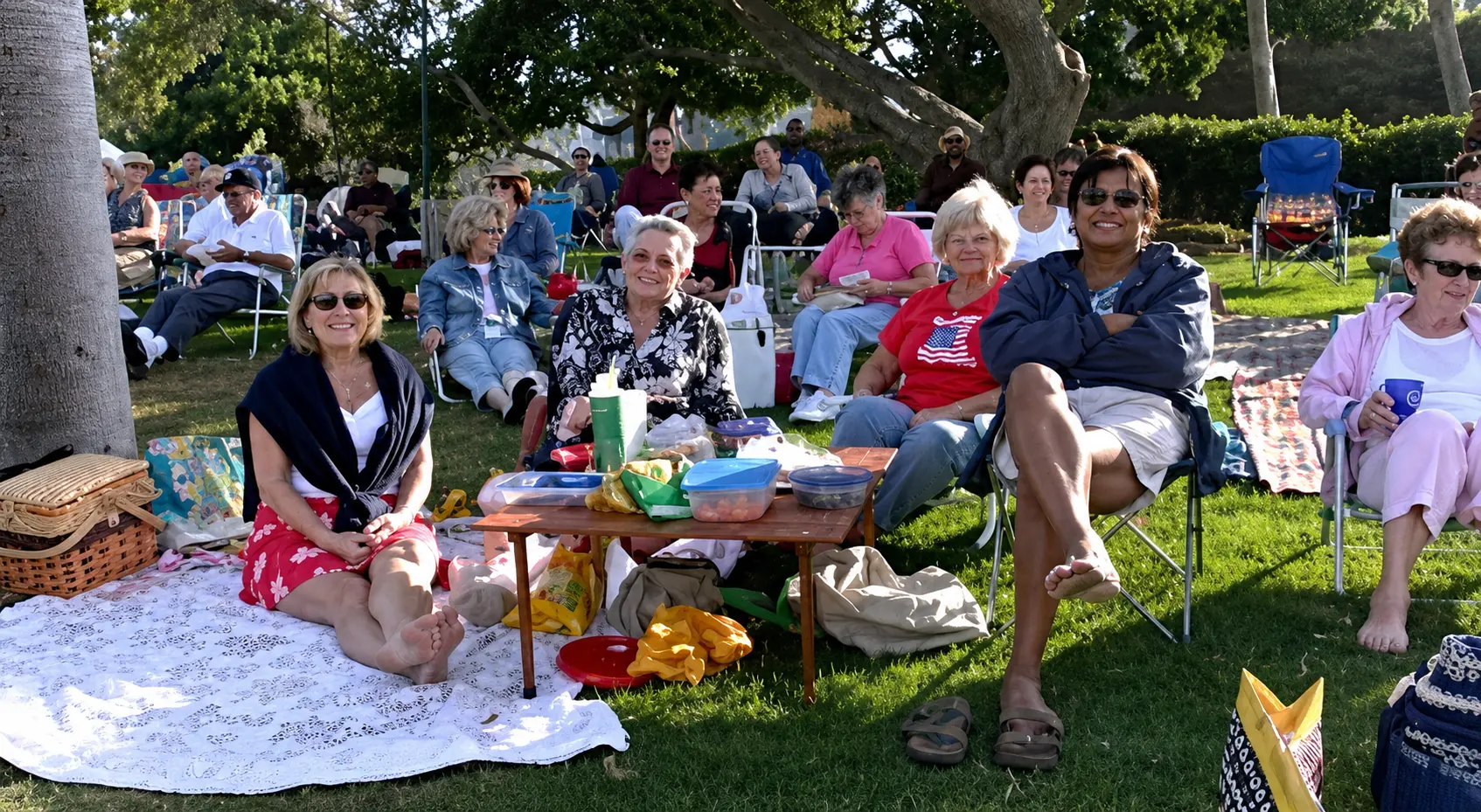 A relaxed outdoor audience enjoying a summer house concert on the lawn