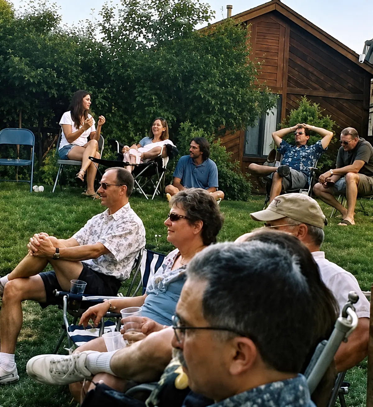 Guests seated on a lawn watching a private backyard house concert